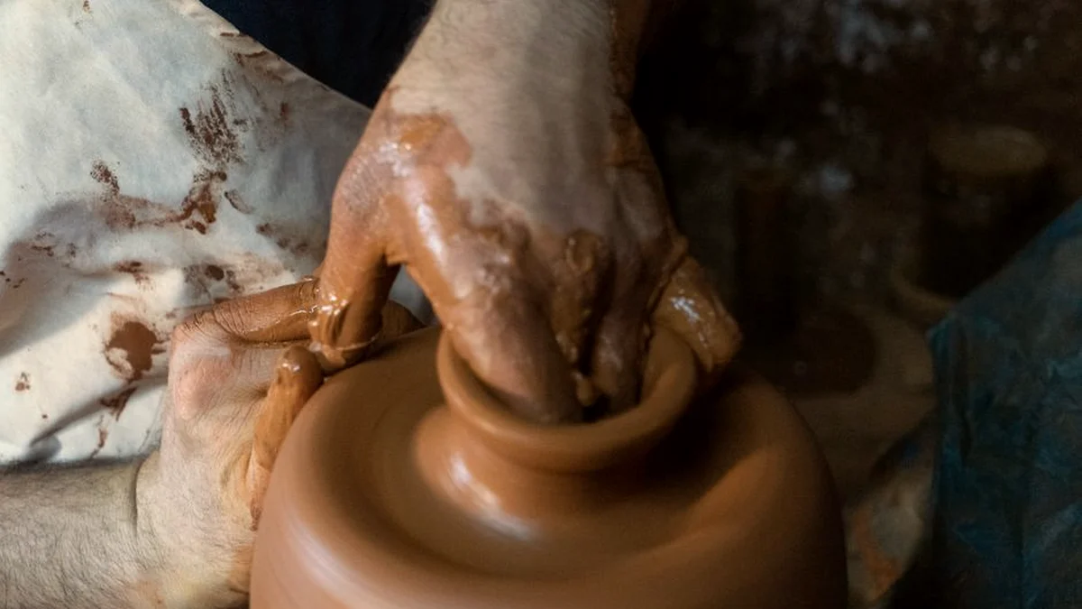 Mains d'un potier qui façonnent un vase sur un tour